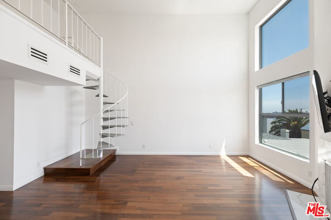 a view of a hallway with wooden floor and stairs