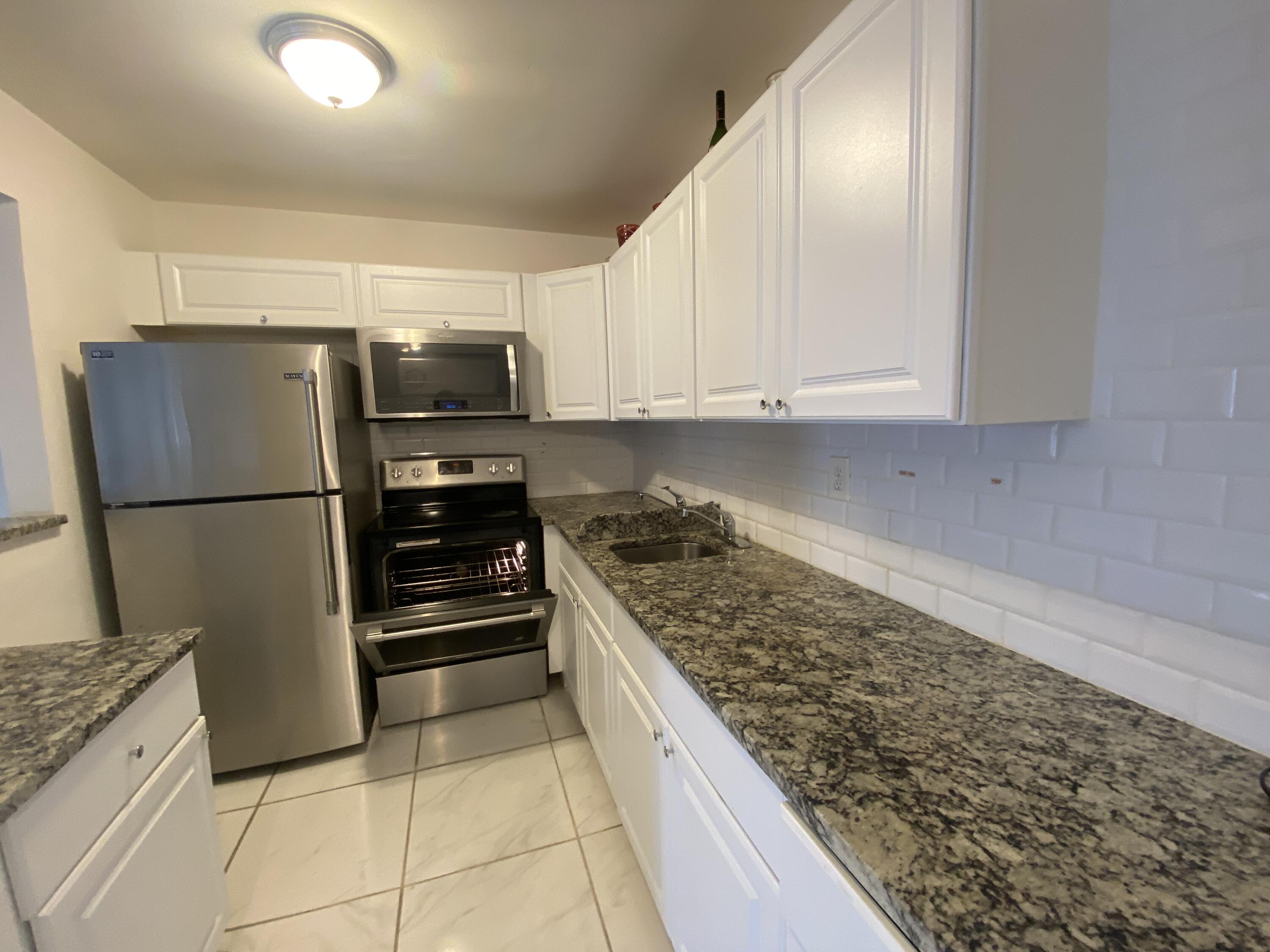 a kitchen with stainless steel appliances granite countertop a refrigerator and a stove