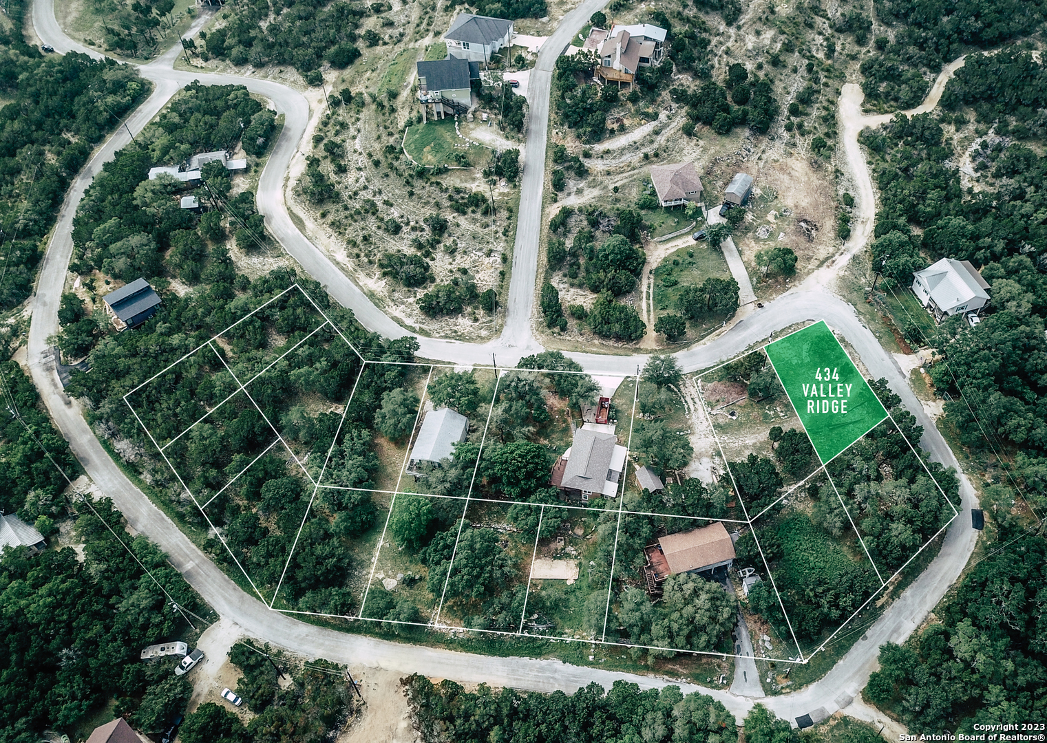 an aerial view of residential house with outdoor space and trees all around