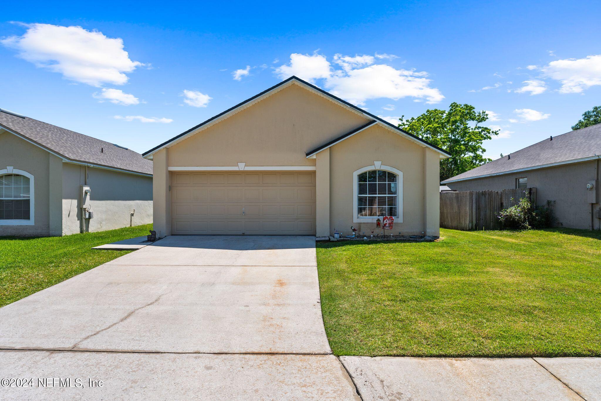 a front view of a house with a yard and garage