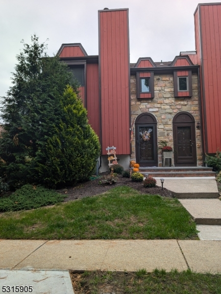 a view of a brick house with a yard and plants