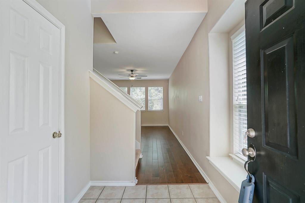 a view of a hallway with wooden floor and staircase