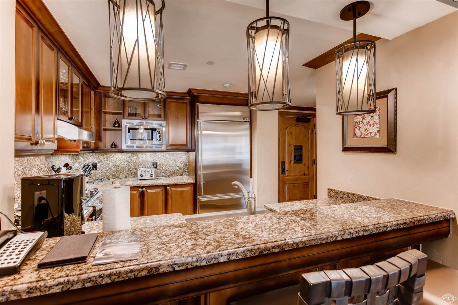 a kitchen with stainless steel appliances granite countertop a sink a stove and a wooden floors