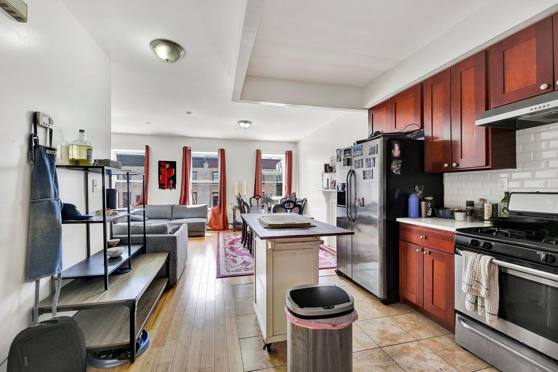 Kitchen with decorative backsplash, light hardwood / wood-style floors, stainless steel appliances, and range hood