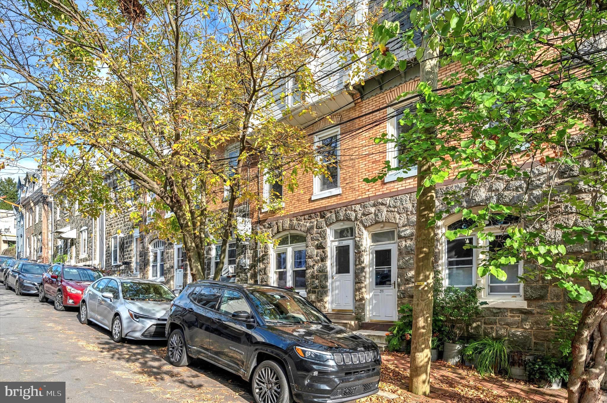 a front view of a building with cars parked