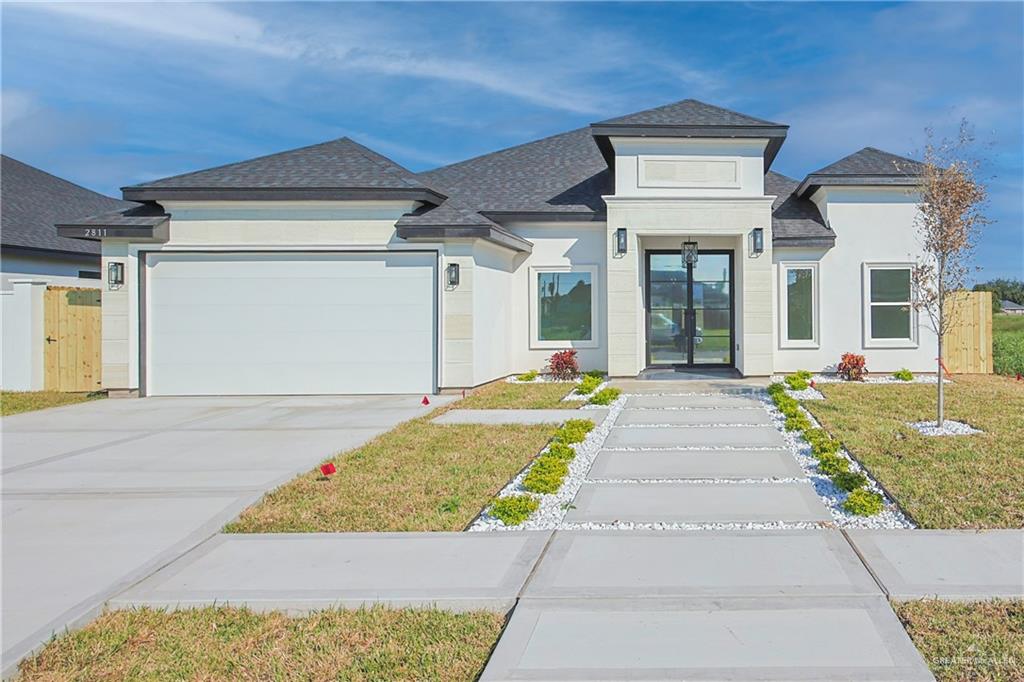 View of front of house with a garage and a front lawn