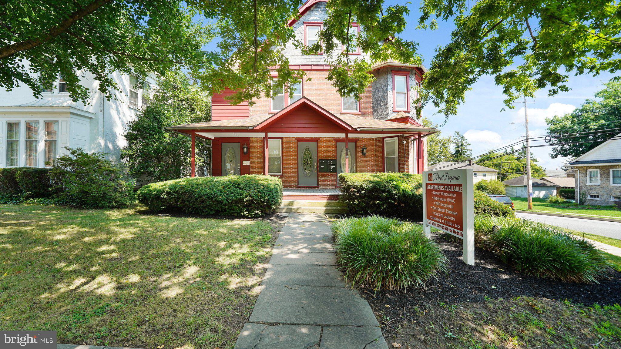 a front view of a house with a yard and trees