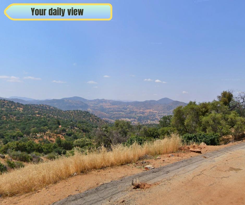 a view of a street with a field of mountains in the background