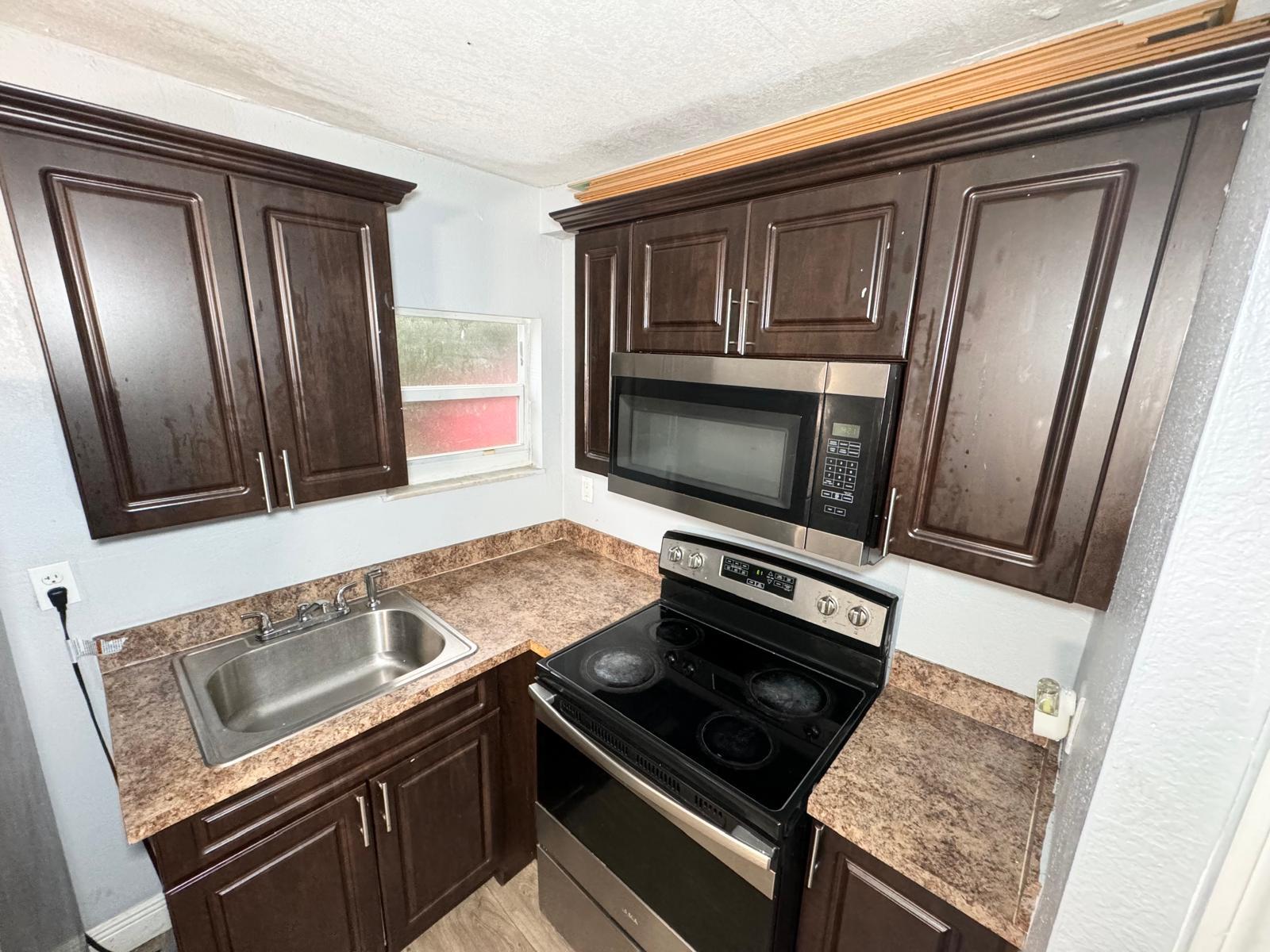 a kitchen with wooden cabinets and stainless steel appliances