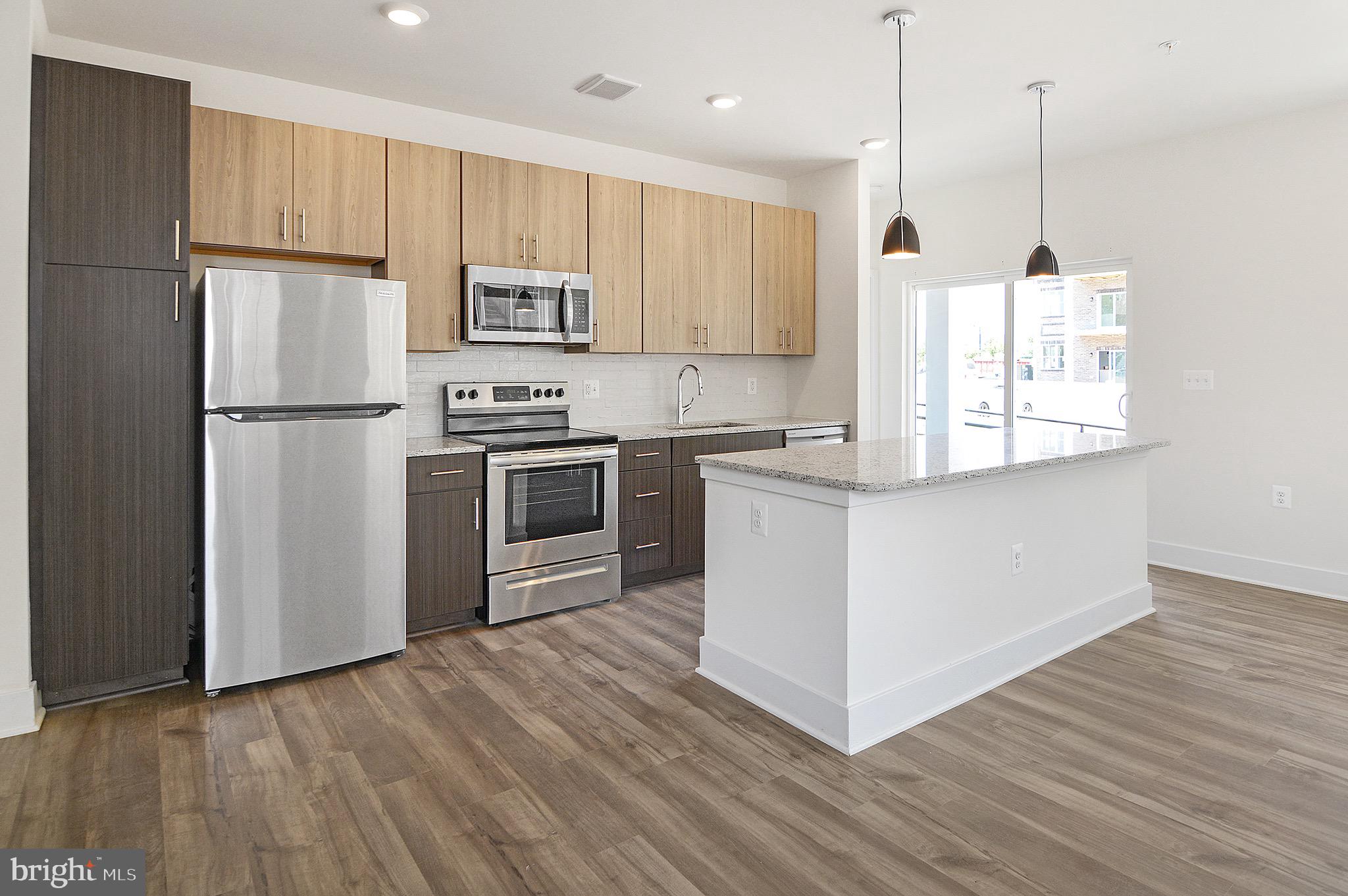 a kitchen with kitchen island white cabinets stainless steel appliances and wooden floor