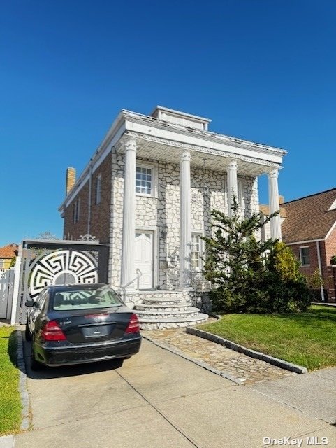 a view of a brick house with a small yard and plants