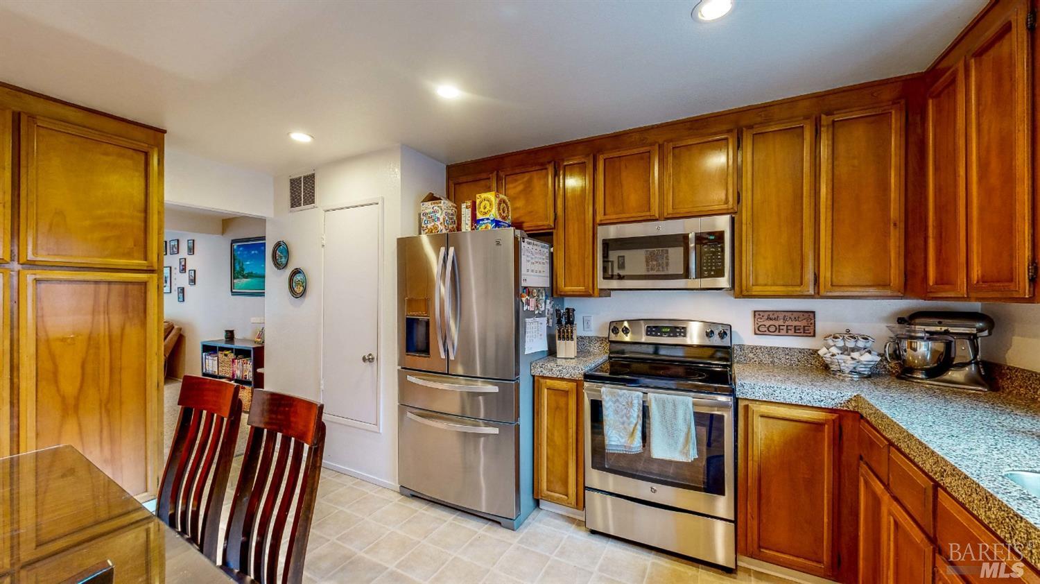 a kitchen with stainless steel appliances granite countertop a refrigerator stove and sink