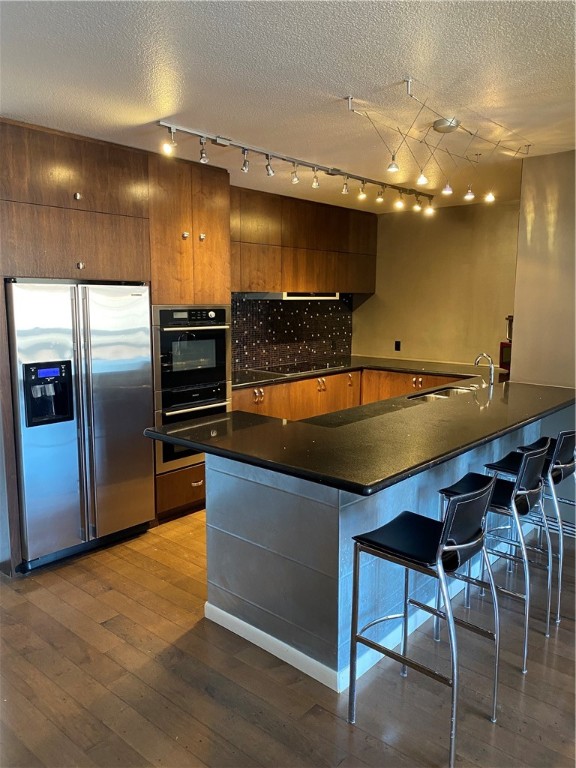 a kitchen with stainless steel appliances a sink and a refrigerator