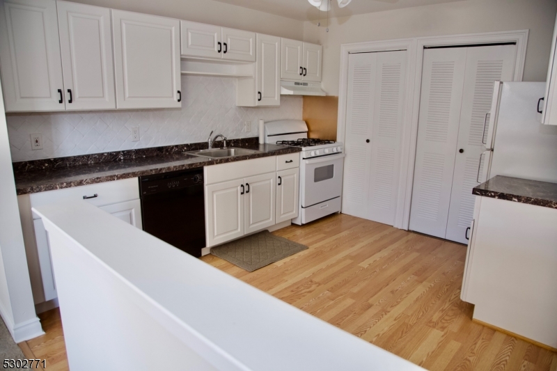 a kitchen with granite countertop a sink stainless steel appliances and cabinets