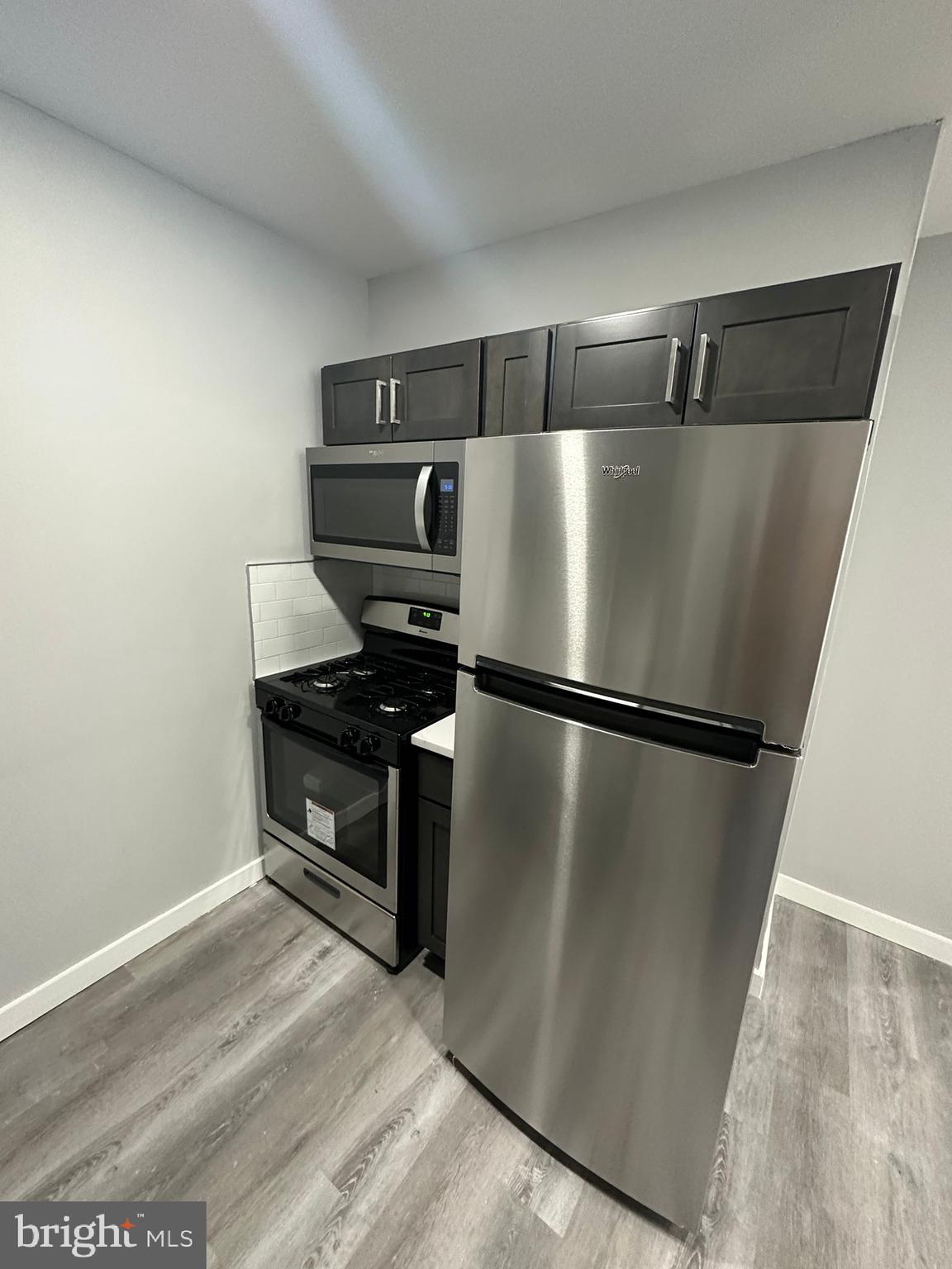 a view of a refrigerator in kitchen and a wooden floor