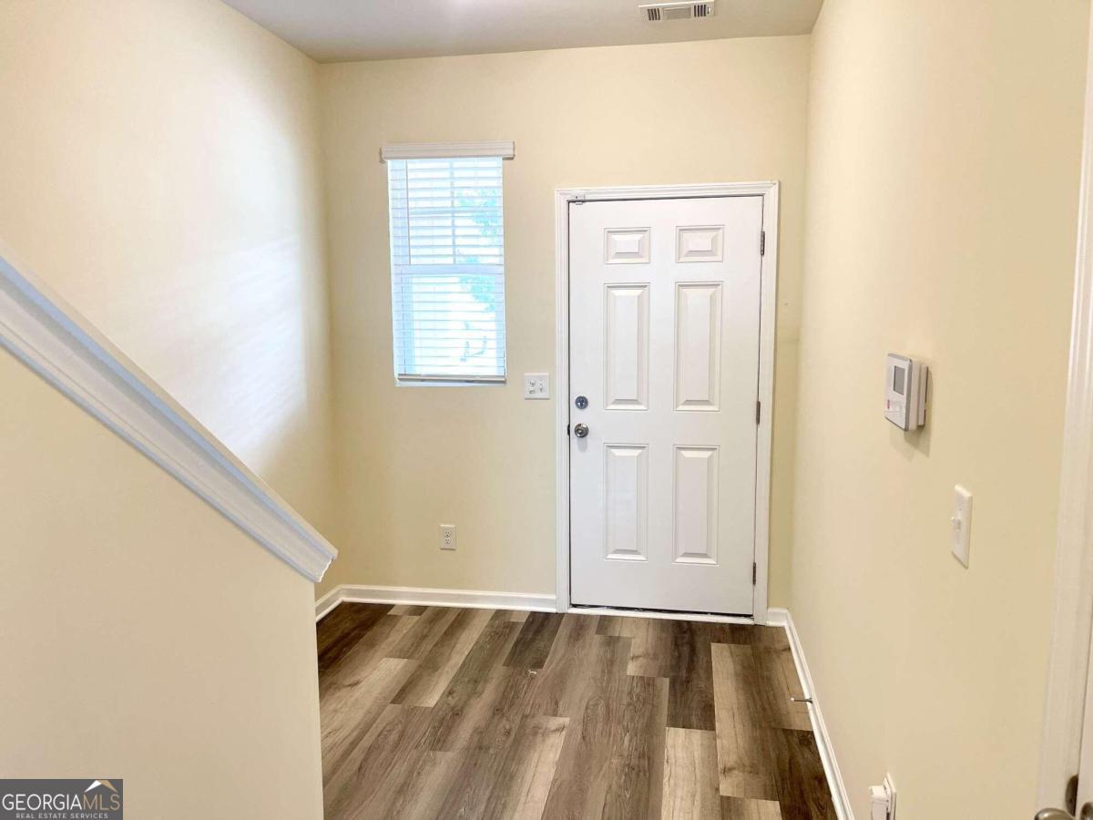 a view of an empty room with wooden floor