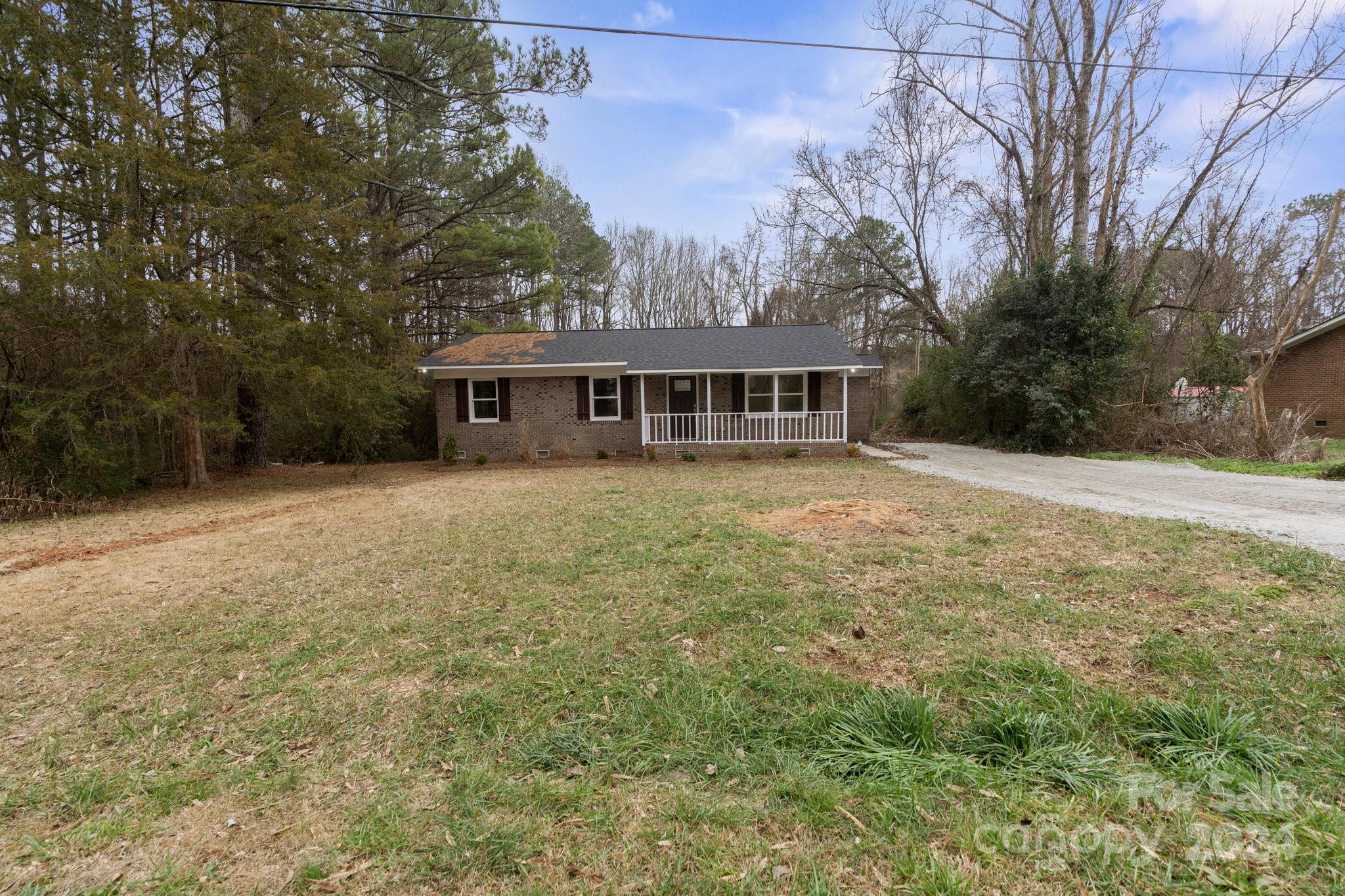 a view of a house with a yard and sitting area