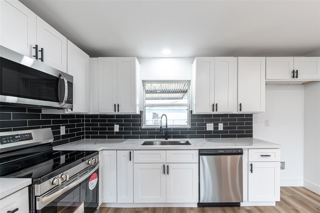 a kitchen with stainless steel appliances a stove a sink and a microwave