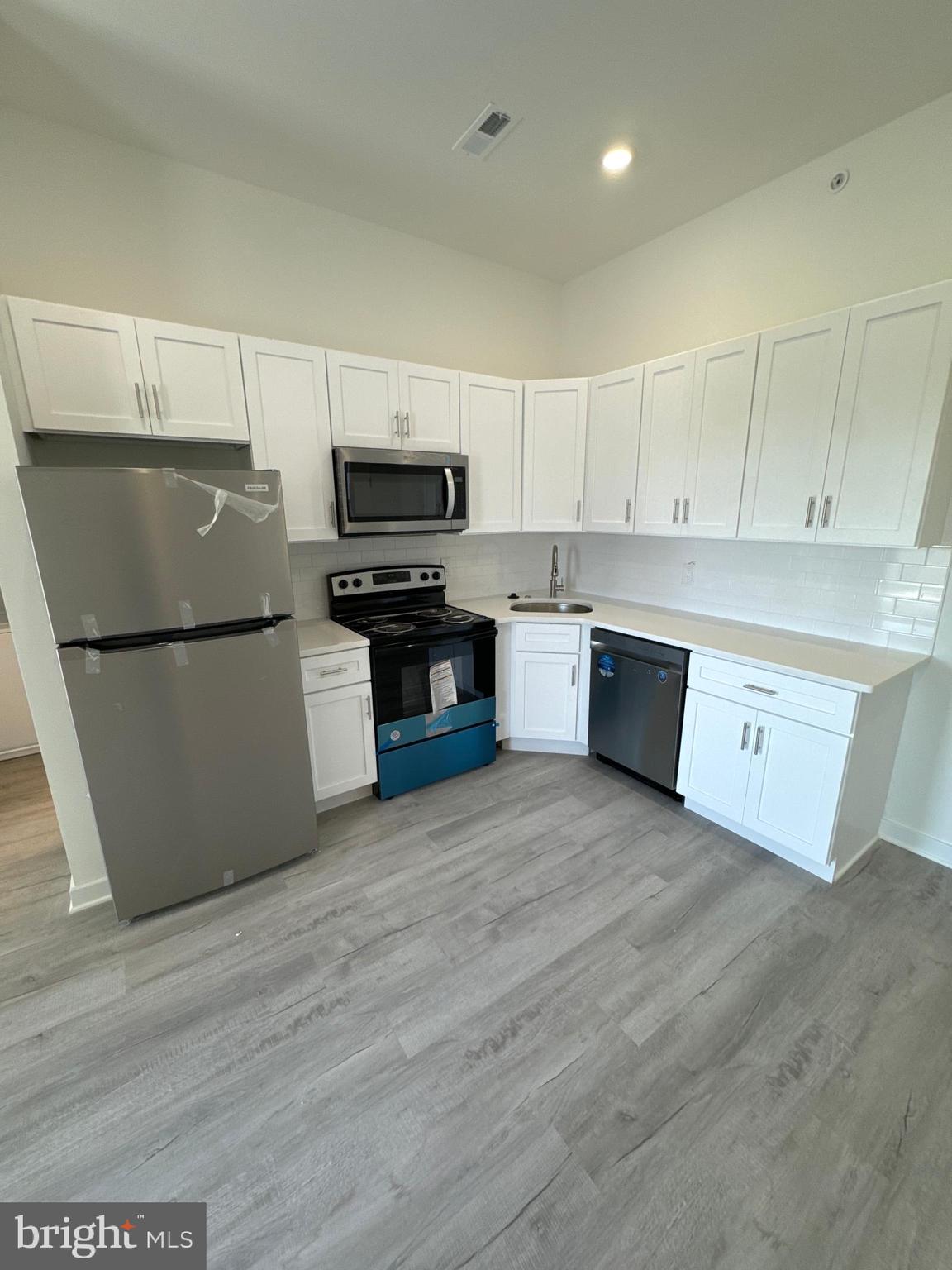 a kitchen with stainless steel appliances a refrigerator sink and microwave