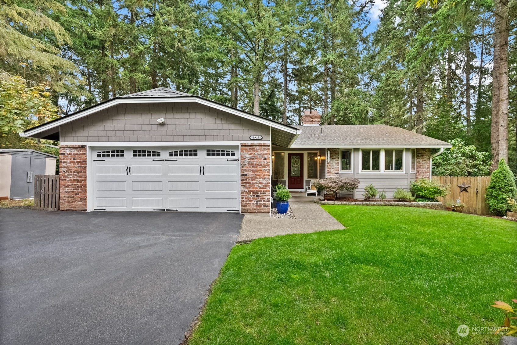 a front view of a house with a yard and trees