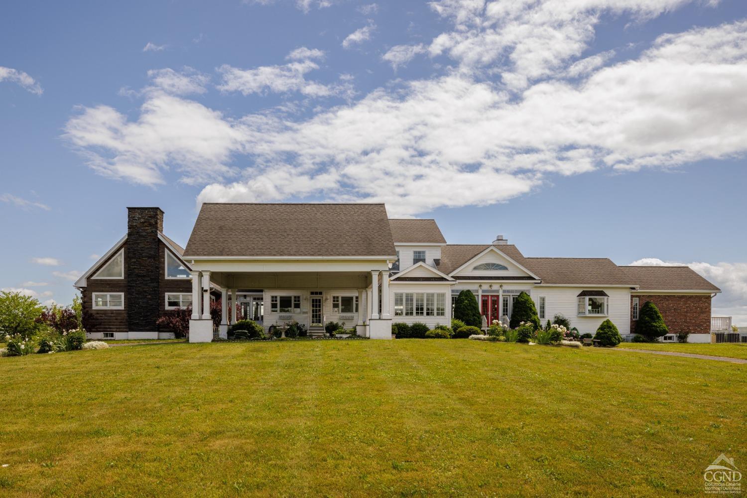 a front view of house with yard and ocean