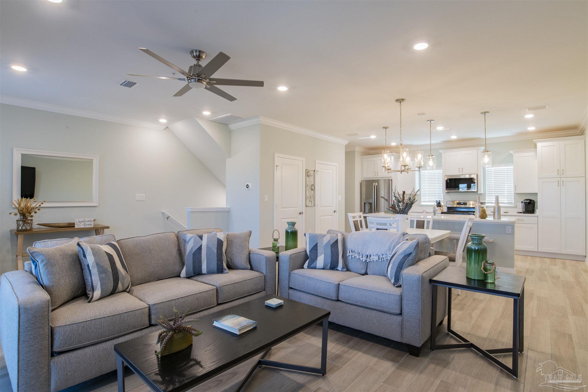 a living room with furniture and a view of kitchen