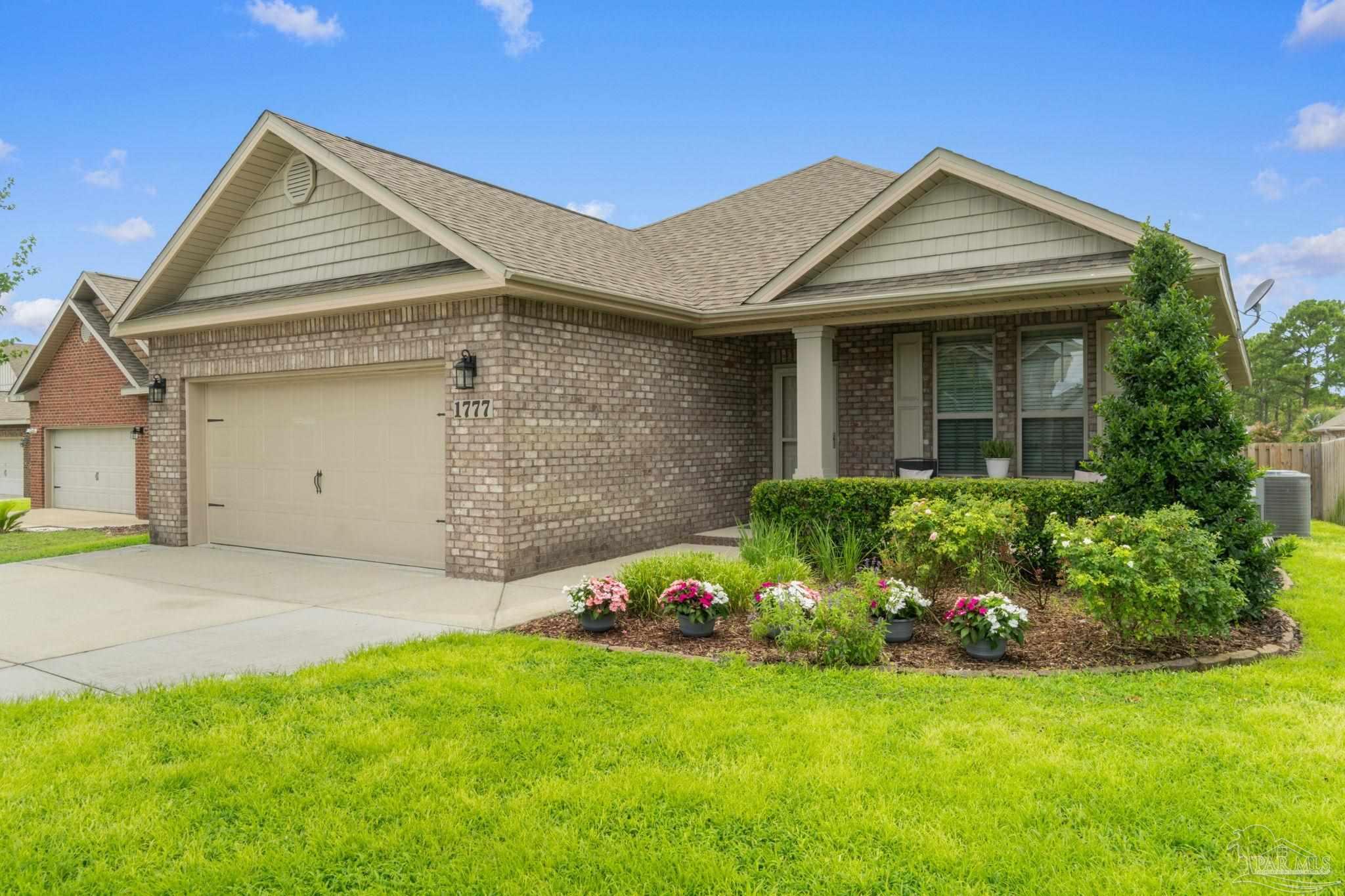 a front view of a house with a garden and plants