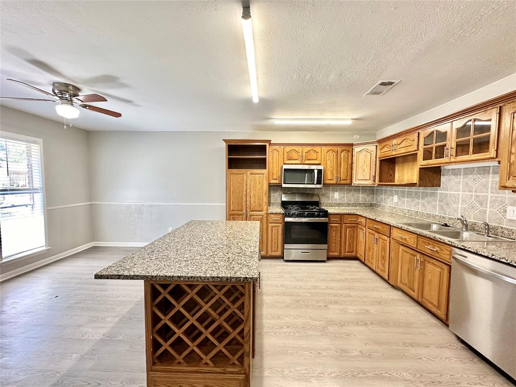 a kitchen with stainless steel appliances granite countertop a stove sink and cabinets