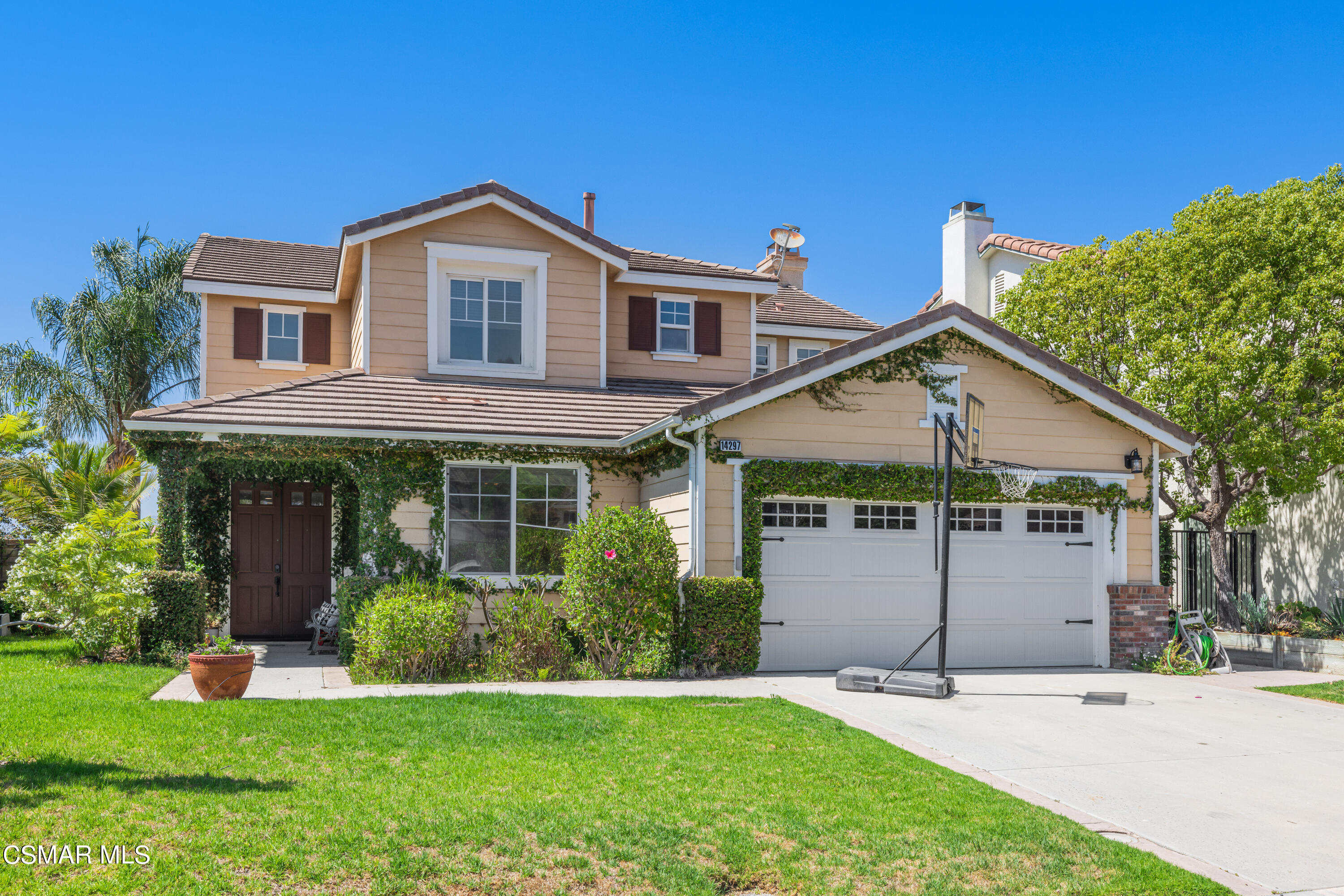 a front view of a house with a yard and potted plants