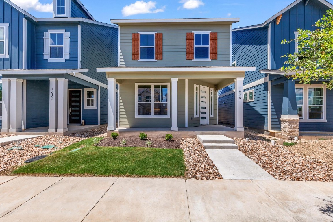 front view of a brick house with a yard