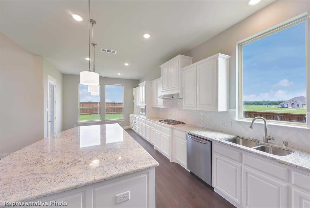 a large kitchen with kitchen island a large counter top space a sink stainless steel appliances and cabinets