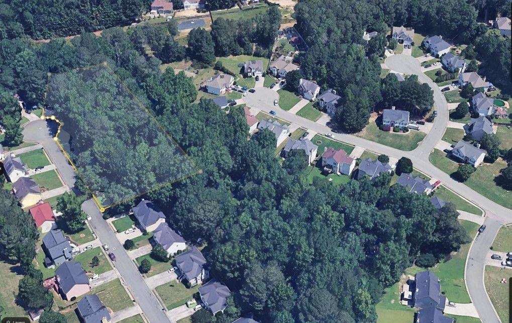 an aerial view of residential house with outdoor space and trees all around