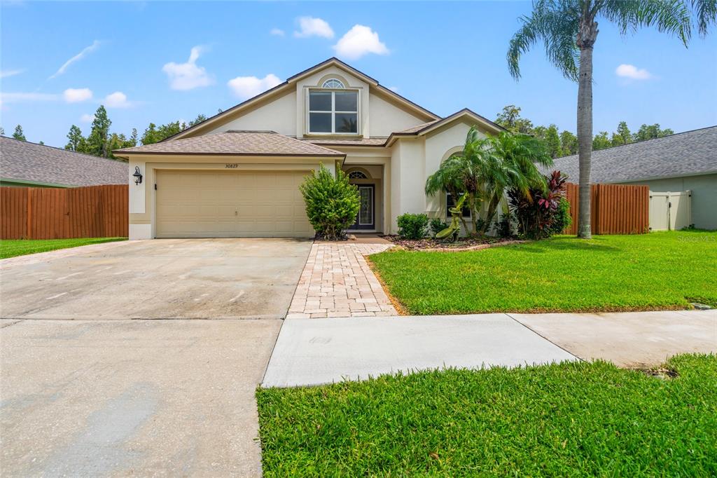 a front view of a house with a yard and a garage