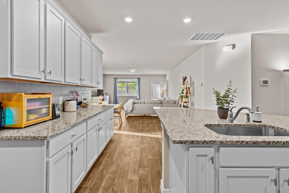 a kitchen with granite countertop a sink and a stove top oven