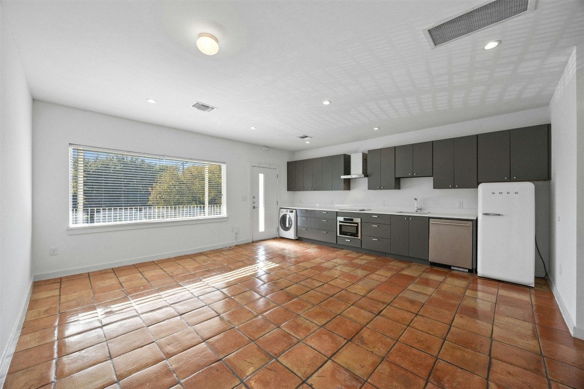 a large white kitchen with a large window