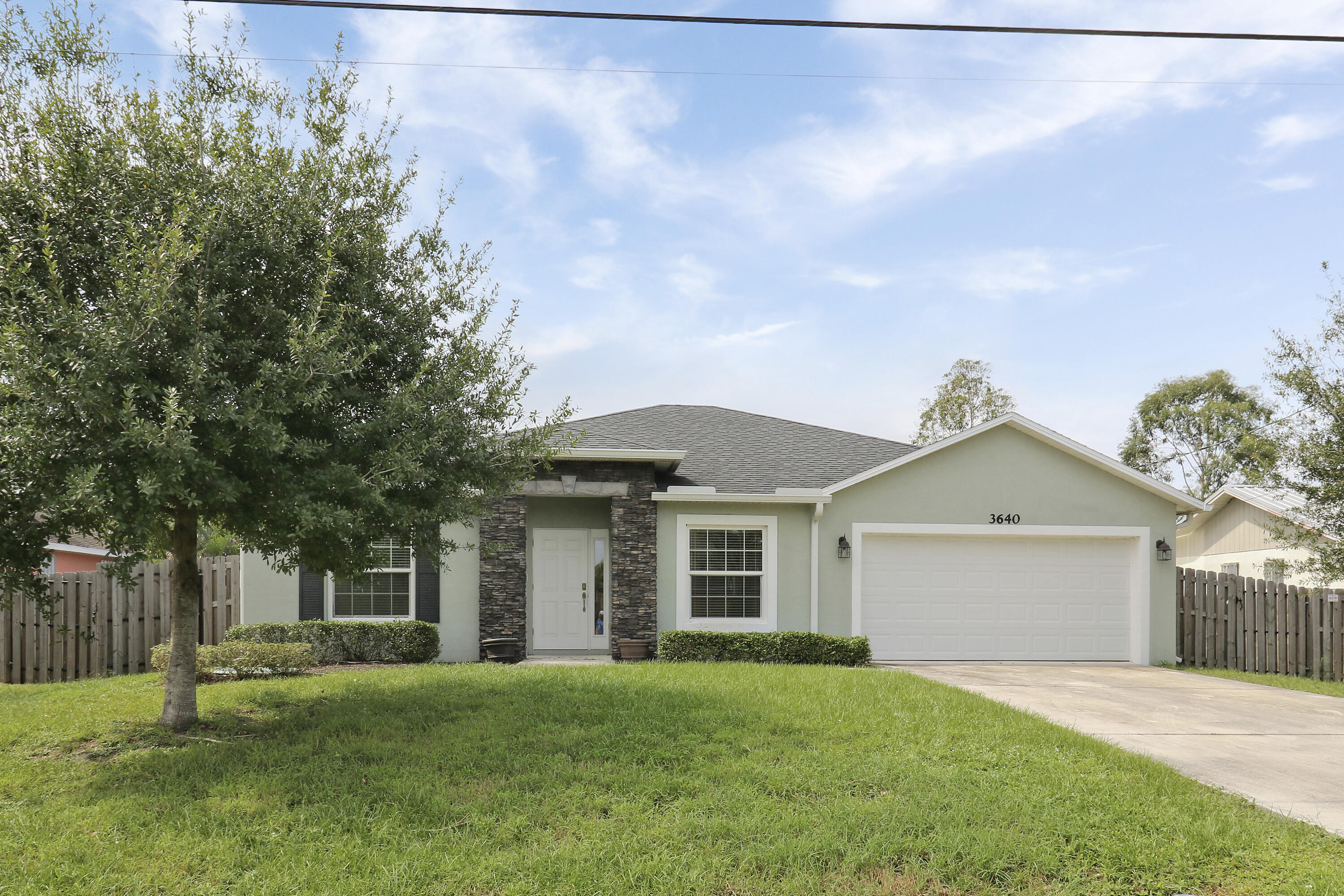 a front view of a house with a garden and yard