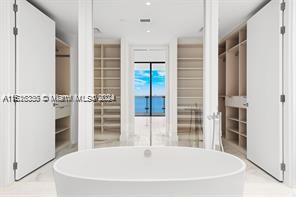 a white bath tub sitting in a bathroom next to a window