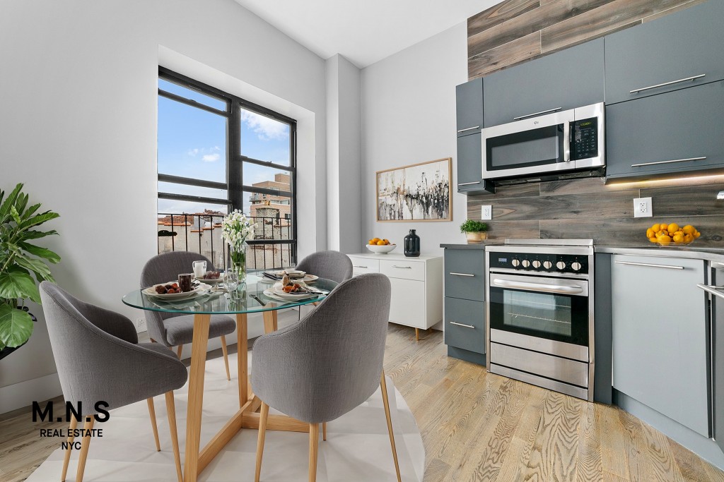 a kitchen with stainless steel appliances a stove a table and chairs