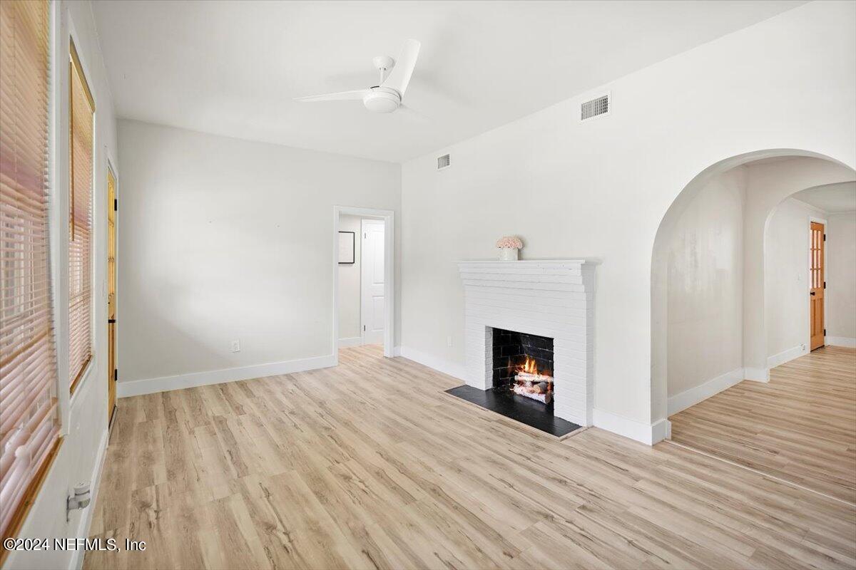 a view of a livingroom with wooden floor and a fireplace