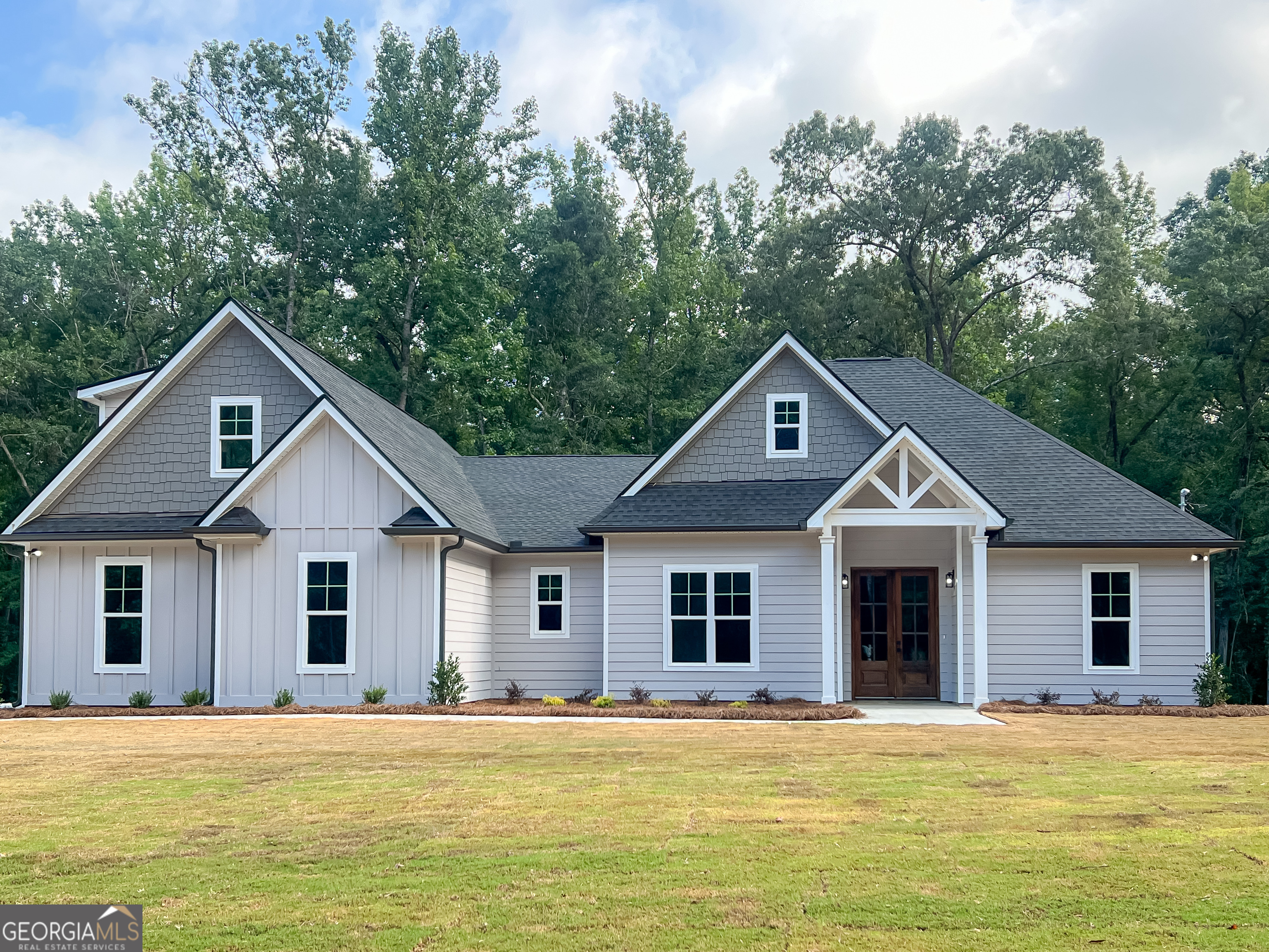 a front view of a house with a garden and yard