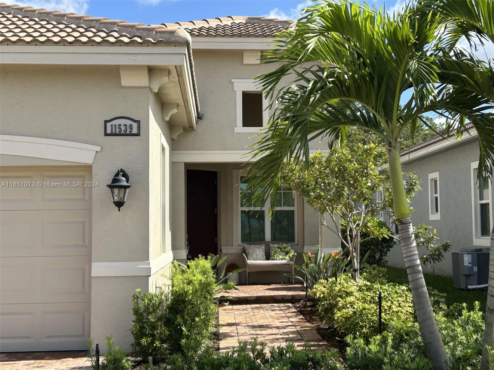 a front view of a house with plants