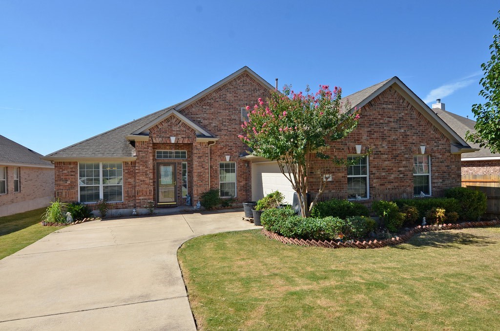 a front view of a house with a yard and potted plants