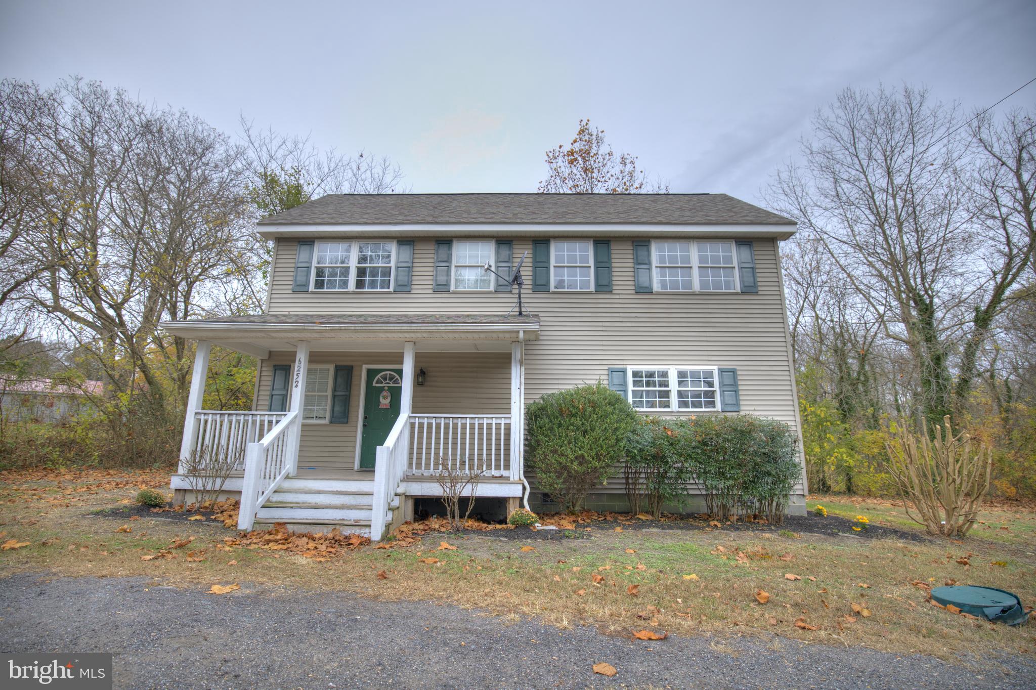 a view of a house with a yard and sitting area