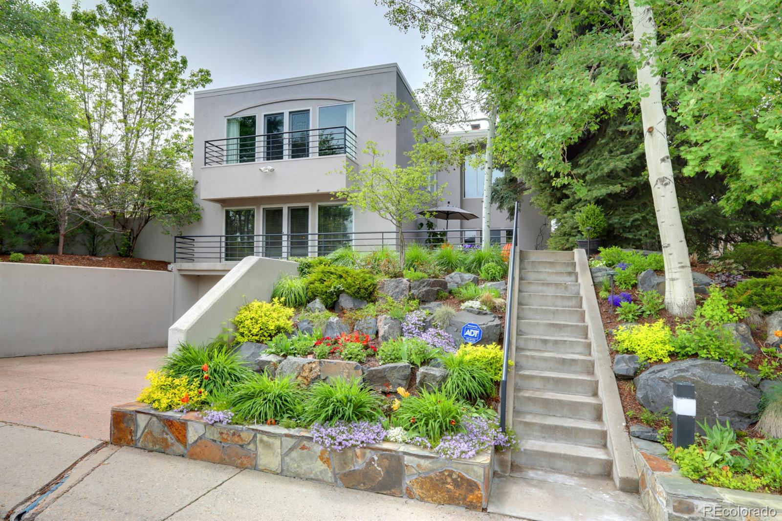 a front view of a house with a yard and potted plants