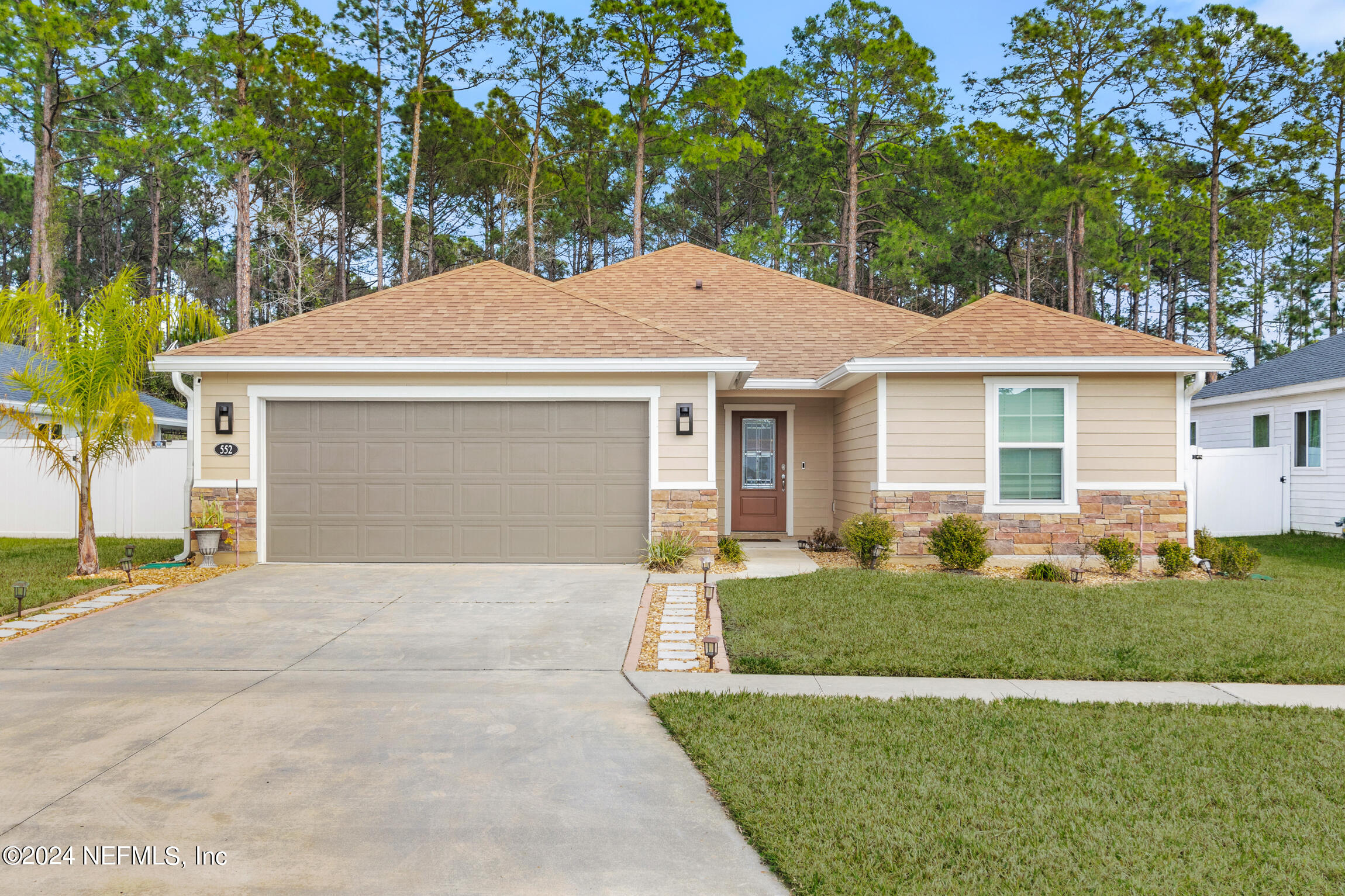 a front view of a house with a yard and garage