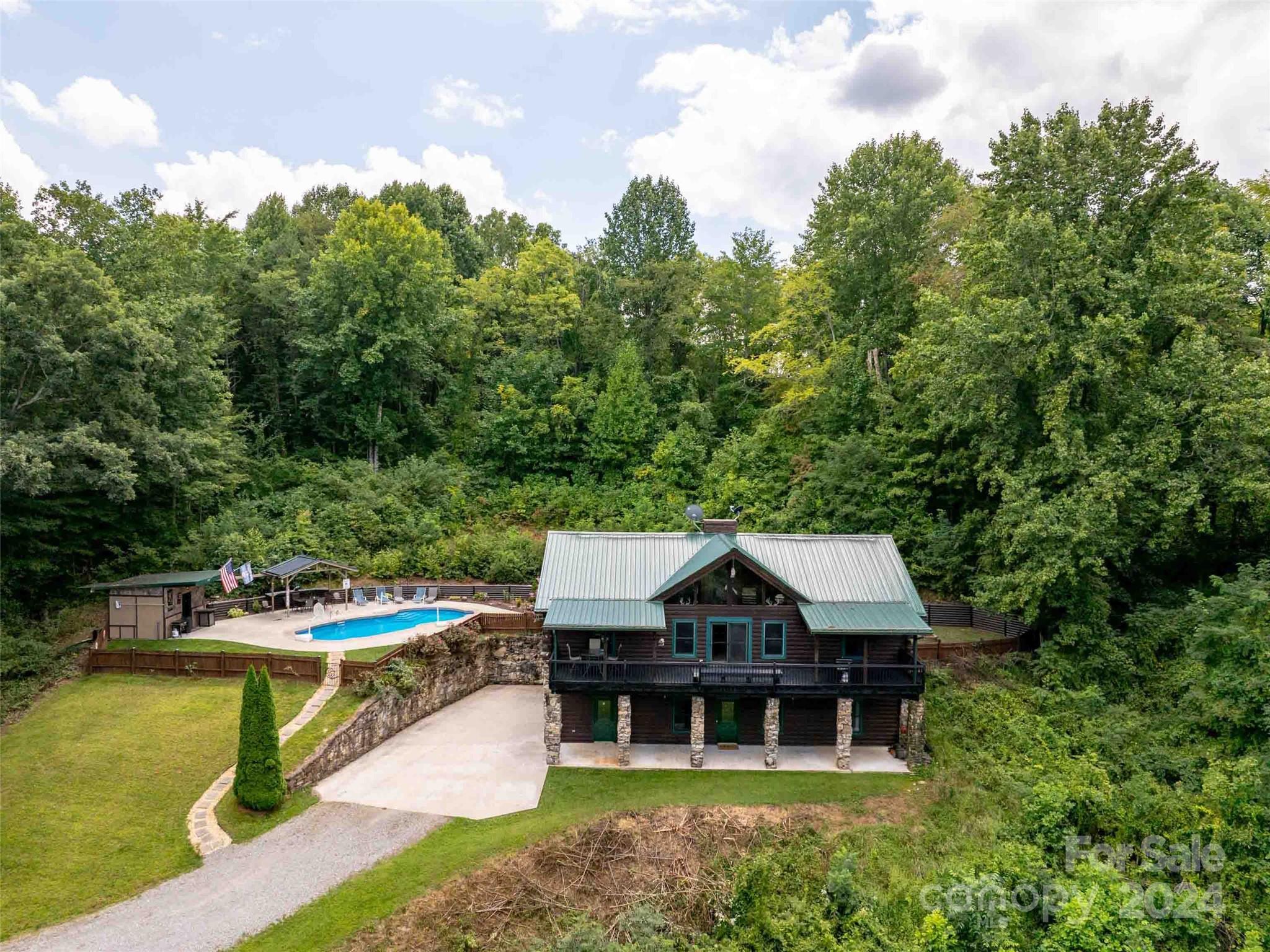 a aerial view of a house with swimming pool and next to a yard