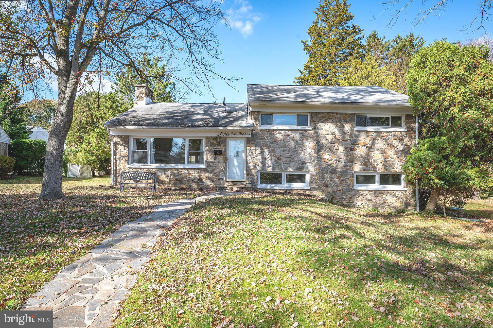 a view of a house with a large tree and plants