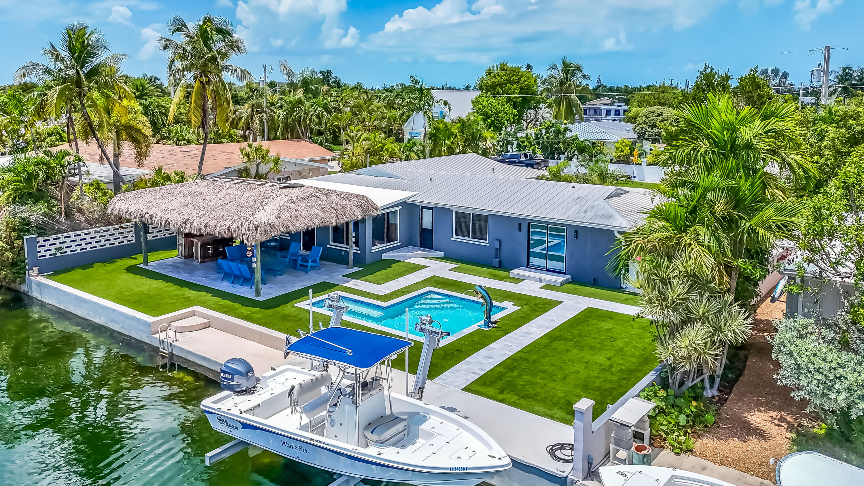 an aerial view of a house with swimming pool and a yard