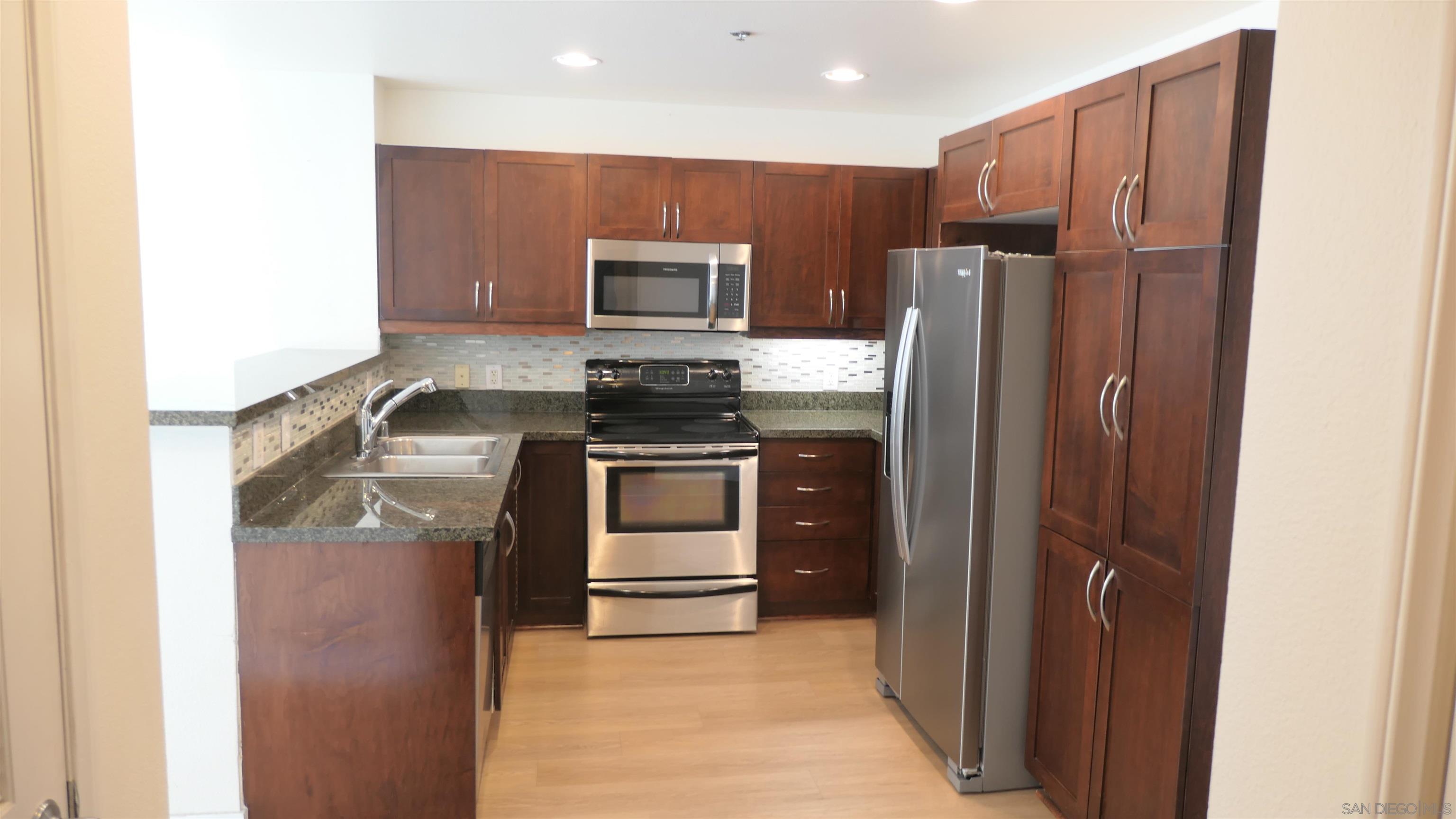 a kitchen with stainless steel appliances granite countertop a refrigerator and a stove