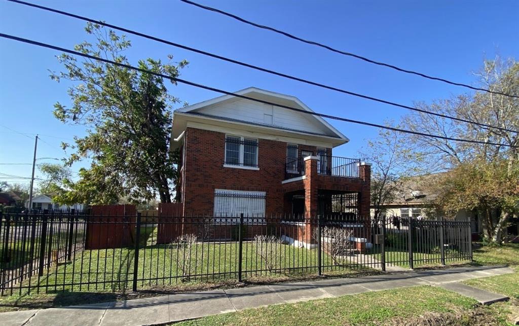 a view of a house with a small yard and wooden fence